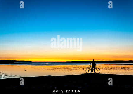 Ardara, County Donegal, Irland Wetter. 29. Juni 2018. Ein Radfahrer beobachtet den Sonnenuntergang auf Irlands "wilden Atlantik Weg' am Ende eines heißen Sommertag an der Nordwestküste. Credit: Richard Wayman/Alamy leben Nachrichten Stockfoto