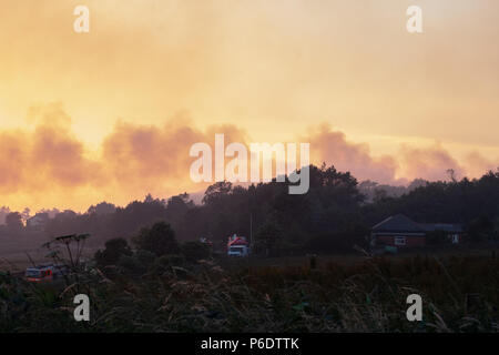 West Pennine Moors, UK, 29. Juni 2018. Der Rauch vom Feuer auf Rivington Pike mit Feuer Motoren auf der Straße unten sichtbar. Stockfoto