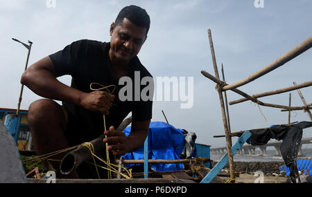 Mumbai, Indien. 28 Juni, 2018. Ein Mann Reparaturen Fischerboot in Worli Koliwada, einem Fischerdorf in Mumbai, Indien, 28. Juni 2018. Credit: Zhang Naijie/Xinhua/Alamy leben Nachrichten Stockfoto