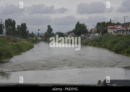 Kaschmir, Indien, 30. Juni 2018. Ansicht einer Überquellenden Jehlum Fluss inmitten regen in Srinagar, die Hauptstadt des Indischen verwalteten Kaschmir, Indien. Eine Flut Alert wurde in Kaschmir am Samstag hörte sich nach dem Wasserstand des Flusses Jhelum stark gestiegen folgenden unaufhörlichen Regen, und Vorsorglich alle Schulen im Kaschmir Abteilung hat auch heute geschlossen. Credit: SOPA Images Limited/Alamy leben Nachrichten Stockfoto