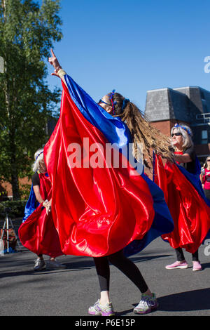 Preston, Lancashire. UK Wetter. 30/06/2018. Animateure am Lancashire Science Festival. Anna Debbage führt die Preston Samba Tänzerinnen, die an der Universität von Central Lancashire eine traditionelle Sundance, der Musik der Worldwise Samba Trommler durchzuführen. Der tanzende Truppe begrüßt Besucher mit Spielen rot & blau Muster von afro-brasilianischen Karneval und candomble Musik inspiriert. Credit: MediaWorldImagesAlamyLiveNews. Stockfoto