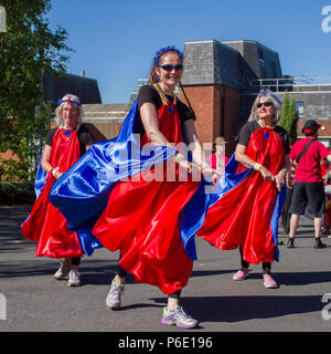 Tänzerin beim Betrachten der Kamera in Preston, Lancashire. Wetter in Großbritannien. 30/06/2018. Entertainer beim Lancashire Science Festival. Anna Debbage führt die Preston Samba Dancers an der University of Central Lancashire an, um einen traditionellen Sundance zur Musik der Worldwise Samba Drummers aufzuführen. Die Tanztruppe begrüßte die Besucher mit roten und blauen Spielmustern, die vom afro-brasilianischen Karneval und der Candomble-Musik inspiriert wurden. Quelle:MediaWorldImagesAlamyLiveNews. Stockfoto