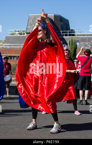 Preston, Lancashire. UK Wetter. 30/06/2018. Animateure am Lancashire Science Festival. Anna Debbage führt die Preston Samba Tänzerinnen, die an der Universität von Central Lancashire eine traditionelle Sundance, der Musik der Worldwise Samba Trommler durchzuführen. Der tanzende Truppe begrüßt Besucher mit Spielen rot & blau Muster von afro-brasilianischen Karneval und candomble Musik inspiriert. Credit: MediaWorldImagesAlamyLiveNews. Stockfoto