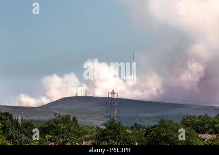 Winter Hill, Lancashire, UK 30/06/2018. Moorland Feuer erweitert, aufgelockert mit leichten Winden mit Geräten Teilnahme aus allen von Lancashire. Eine umfangreiche Pall von beißender Rauch reicht nun von Manchester nach Soweit der Westküste, mit Hauseigentümern beraten zu halten Windows herunterfahren. Feuerwehrleute gegen die Flammen in der Nähe eines großen TV-Sender erwarten, dass es Tage dauert entweder zu löschen oder zu brennen. Hat das Feuer "INTENSIVIERTE" folgenden erhöhten Winde während des Nachmittags, Lancashire Feuerwehr sagte. Credit: MediaWorldImages/AlamyLiveNews. Stockfoto