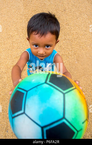 Einige der Kinder spielen Fußball auf trockenen Paddy in der Sonne an Ishwardi Upazila, in Rajshahi Pabna Bezirk Division, Bangladesch. Stockfoto