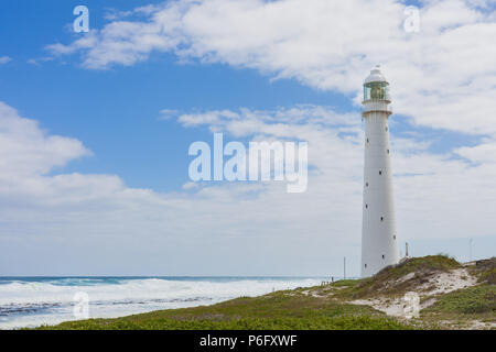 Leuchtturm auf einer zerklüfteten Küstenlinie bei Tag. In Kapstadt Südafrika an der Westküste der Halbinsel fotografiert. Stockfoto