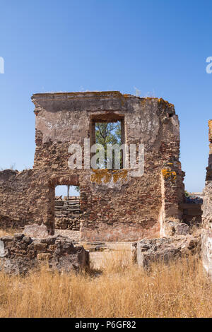 Details der Architektur der Ruine der Burg Castro Marim, Algarve, Portugal. Vordere Teil des Hauses mit Fenster und Tür. Strahlend blauen Himmel. Stockfoto