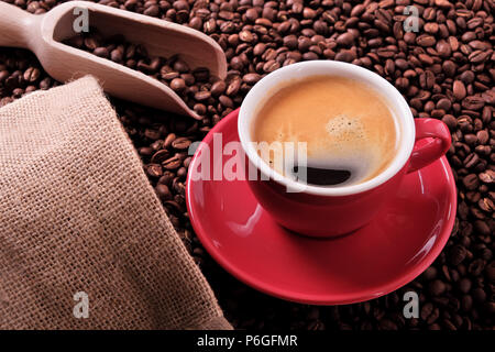 Rote Kaffeetasse mit Espresso und gerösteten Bohnen Stockfoto