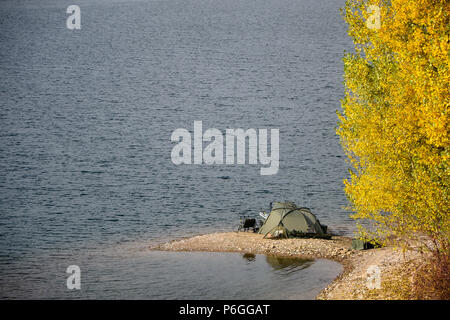 Einer Ruhigen Herbsttag, Zelt eines Fischers, die auf dem Rand des Sees. Gelbe Blätter von Bäumen. Stockfoto