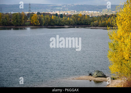 Einer Ruhigen Herbsttag, Zelt eines Fischers, die auf dem Rand des Sees. Gelbe Blätter von Bäumen. Stockfoto