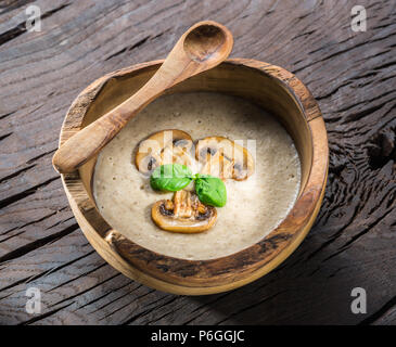 Rahm Suppe mit Pilzen auf Holztisch. Ansicht von oben. Stockfoto