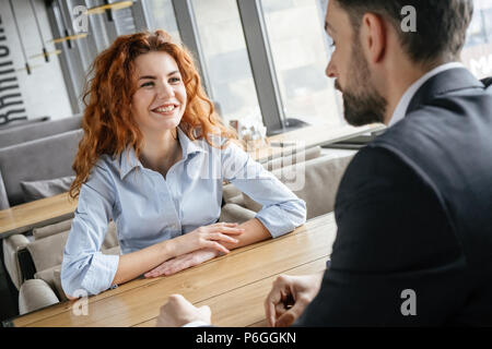 Mann und Frau in Business Lunch im Restaurant am Tisch Geschäftsfrau, sitzen an Kollege lächelnd Fröhliches diskutieren Projekt konzentriert Stockfoto