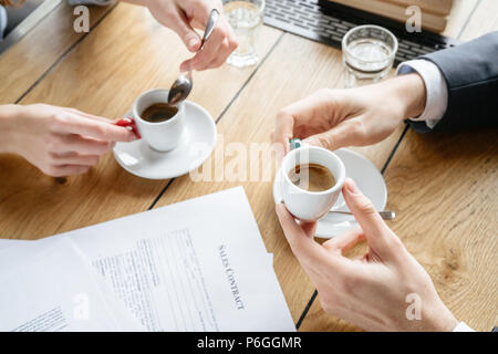 Mann und Frau in Kaffeepause im restaurant am Tisch Holding heißen Espresso Tassen sitzen Top View close-up Stockfoto