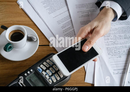 Geschäftsmann auf Business Lunch im Restaurant am Tisch sitzen die Zahlung online über Mobile Payment holding Smartphone close-up Stockfoto