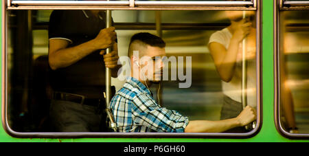 Belgrad, Serbien - Mai 31, 2018 : das Panning Schuß des jungen Mannes mit Kopfhörern in Plaid Shirt sitzen und andere Passagiere Reiten in einem Fenster Sitz einer c Stockfoto