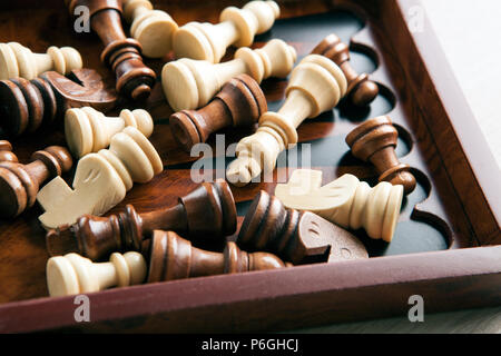 Holz- Schachfiguren liegen in einem Schachbrett Nahaufnahme Stockfoto