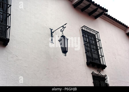 Eine weiße Wand in Bogota mit hängenden Straße Licht und viel Sicherheit in der Form von dekorativen Balken auf Windows. Stockfoto