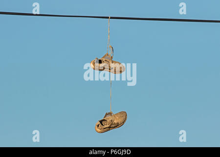 Paar Sportschuhe über ein Telefon Kabel hängend, Cambridgeshire Stockfoto