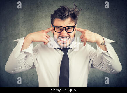 Junger bärtiger Mann im Stress holding Finger auf Tempel und Kamera in Ärger und Ablehnung Stockfoto