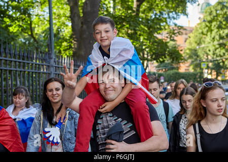 St. Petersburg, Russland - 25. Juni 2018: lächelnd Vater seinen Sohn trägt auf seinen Schultern, der Rückkehr von Fußball Spiel Wm in der Masse der Fußball-fa Stockfoto