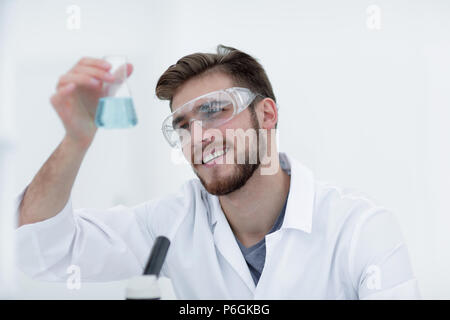 Closeup. Chemiker Holding ein Becherglas mit einer Lösung Stockfoto