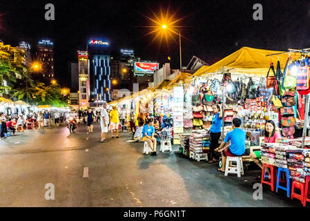 Vietnamesische Kinder spielen in der Straße in der Nähe des Nachtmarktes in Ho Chi Minh (Saigon) Stockfoto