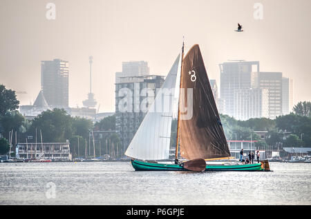 Rotterdam, Niederlande, 30. Mai 2018: Eine traditionelle Friesischen skutsje Yacht segeln auf See Kralingse Plas mit der Skyline im Hintergrund Stockfoto