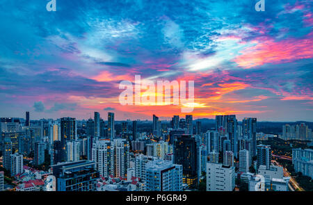 Hohe Betrachtungswinkel der Stadt gegen die drastischen Himmel und Wolken bei Sonnenuntergang im Stadt-staat Singapur Stockfoto