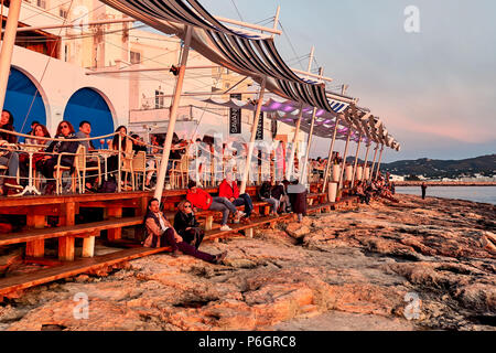 Insel Ibiza, Spanien - 1. Mai 2018: Massen von Menschen treffen, den Sonnenuntergang auf der Terrasse des Cafe del Mar. Dieser Ort ist berühmt für den Blick auf die Sonne Stockfoto