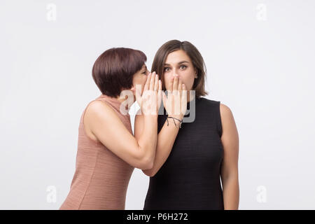 Frauen Mutter und Tochter klatschen und sagen ein Geheimnis Stockfoto