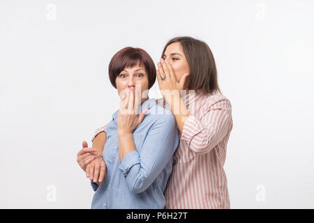 Frauen Mutter und Tochter klatschen und sagen ein Geheimnis Stockfoto