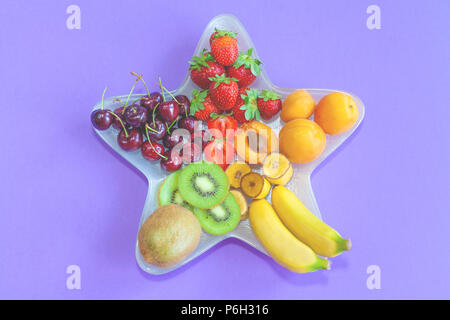 Sommer Obst auf einem sternförmigen Platte - lila Hintergrund (zentriert Layout) Stockfoto