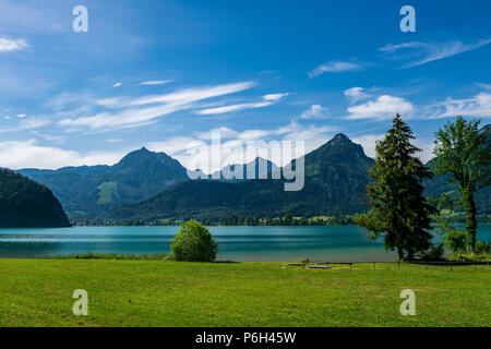 See namens Wolfgangsee in Österreich mit Bergen im Hintergrund und Wolken am Himmel und Gras in der Front Stockfoto