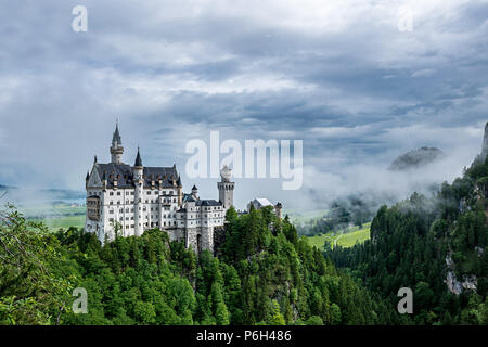 Schloss Neuschwanstein in Bayern mit Wolken am Himmel und ein wenig Nebel an einem sonnigen Tag Stockfoto