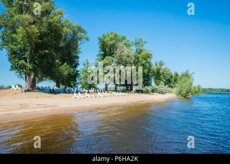 Sandstrand mit Liegestühlen am Ufer der Wolga in Samara, Russland. An einem sonnigen Sommertag. Stockfoto