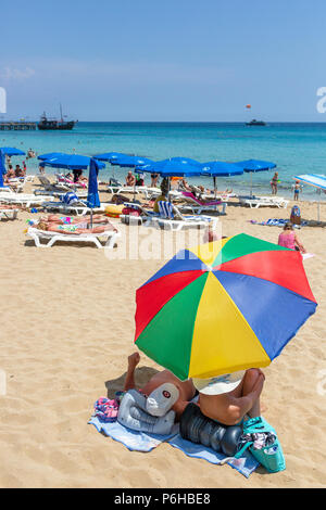 Urlauber Sonnenbaden am Strand von Protaras gelegen, in der Nähe von Ayia Napa, Zypern Stockfoto