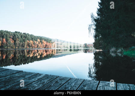 Überlegungen zu einem See mit einem Steg in den Bayerischen Wald im Herbst Stockfoto