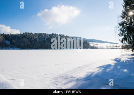 Gefrorenen See mit Sonne am Himmel im Winter im Bayerischen Wald. Stockfoto