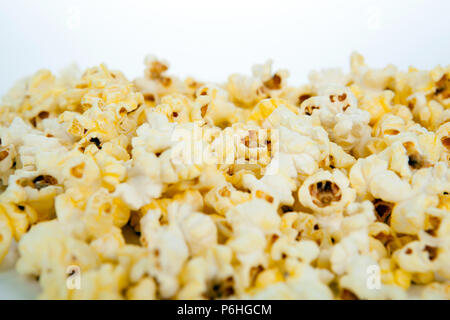 Viel Popcorn auf weißem Hintergrund Stockfoto