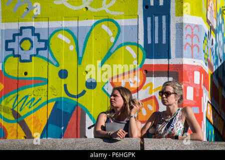 Menschen gehen in der Sonne auf der South Bank in London, als Leute die anhaltende Bann von heißem Wetter genießen. Stockfoto