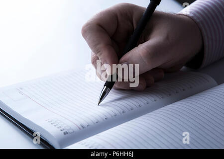 Tagebuch und die menschliche Hand mit einem Pen close-up Stockfoto