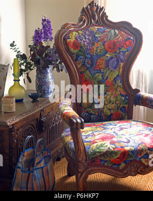 In der Nähe von hellen geblümten gepolsterte Sessel und im Viktorianischen Stil aus Holz geschnitzte Brustkorb Stockfoto