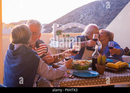 Nette Gruppe der kaukasischen erwachsener Menschen in Glück bleiben zusammen für Abendessen im Freien auf der Terrasse. liebe und freundschaft Konzept mit herrlichen Ausblick. v Stockfoto