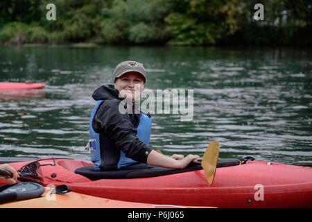 Junge blonde Mädchen schwimmt auf einer Sport Boot Kajak an einem schönen Fluss Stockfoto