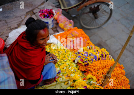 Eine Frau verkauft Blumen am Durbar Square in Kathmandu, Nepal. Stockfoto