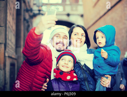 Mama und Papa mit ihren kleinen Kindern tun selfie im Freien. Stockfoto