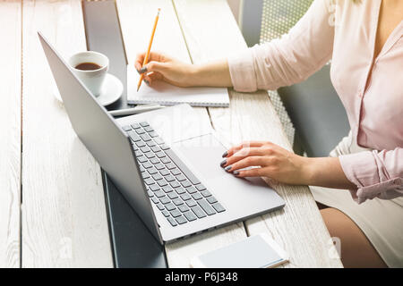 Business, Bildung, Menschen und Technologie Konzept - aus der Nähe von weiblichen Händen Arbeiten am Laptop, auf Papier, Kaffee auf den Tisch Stockfoto
