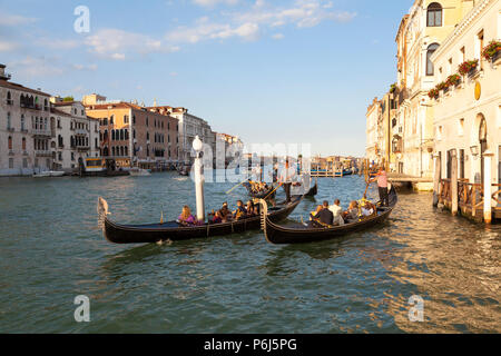 Touristen, romantischen Gondelfahrten bei Sonnenuntergang auf dem Canal Grande, Venedig, Venetien, Italien. Goldene Stunde mit Reflexionen. Stockfoto