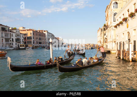 Touristen, romantischen Gondelfahrten bei Sonnenuntergang auf dem Canal Grande, Venedig, Venetien, Italien. Goldene Stunde mit Reflexionen. Stockfoto