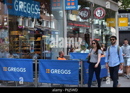 Menschen gehen vorbei an einer Reihe von Cafés und Take-away Läden einschließlich sandwichmaker und Bäckerei Greggs, Mikel Kaffee und Essen. der Tottenham Court Road in Stockfoto